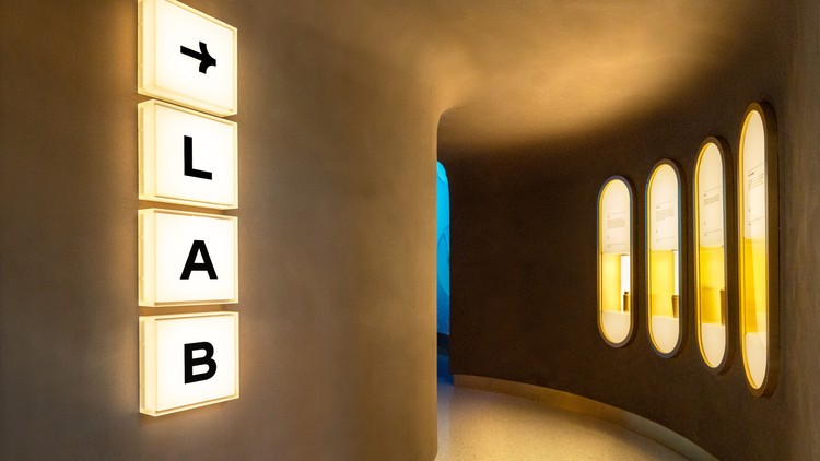 The lab sign glowing in the curved corridor