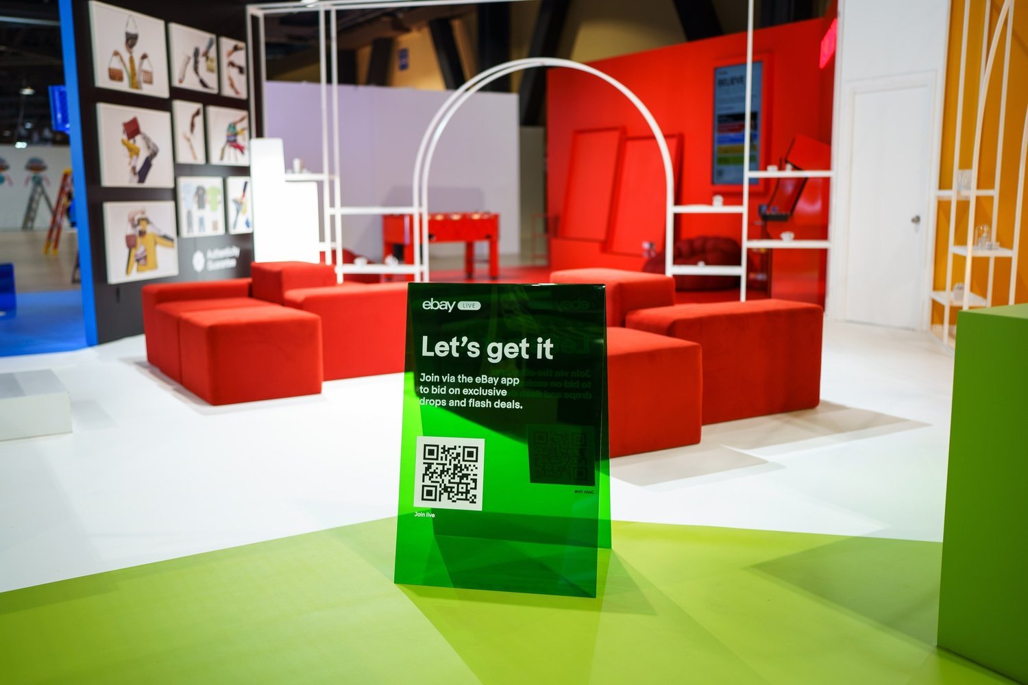eBay-red modular seating behind the “Let’s get it” auction sign