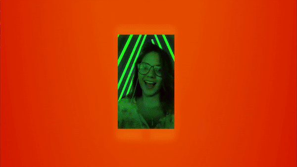 A fan's camera framed in neon during the show