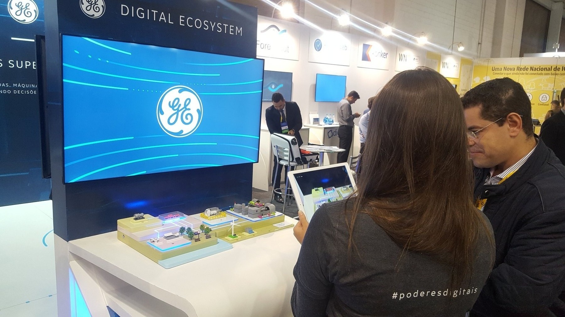 Visitors reading the model through the tablet on the booth floor