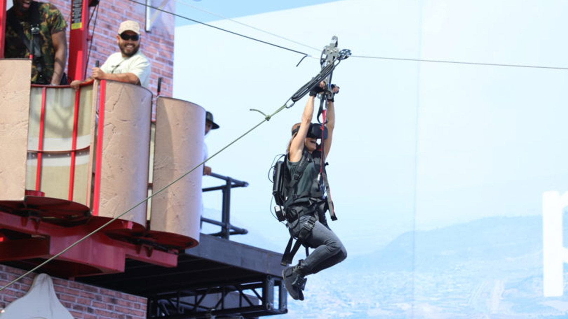 A visitor riding the zipline over the set