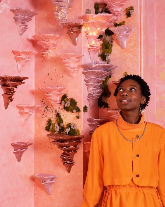 Ceramic mushrooms and moss climbing JOAN's pink wall